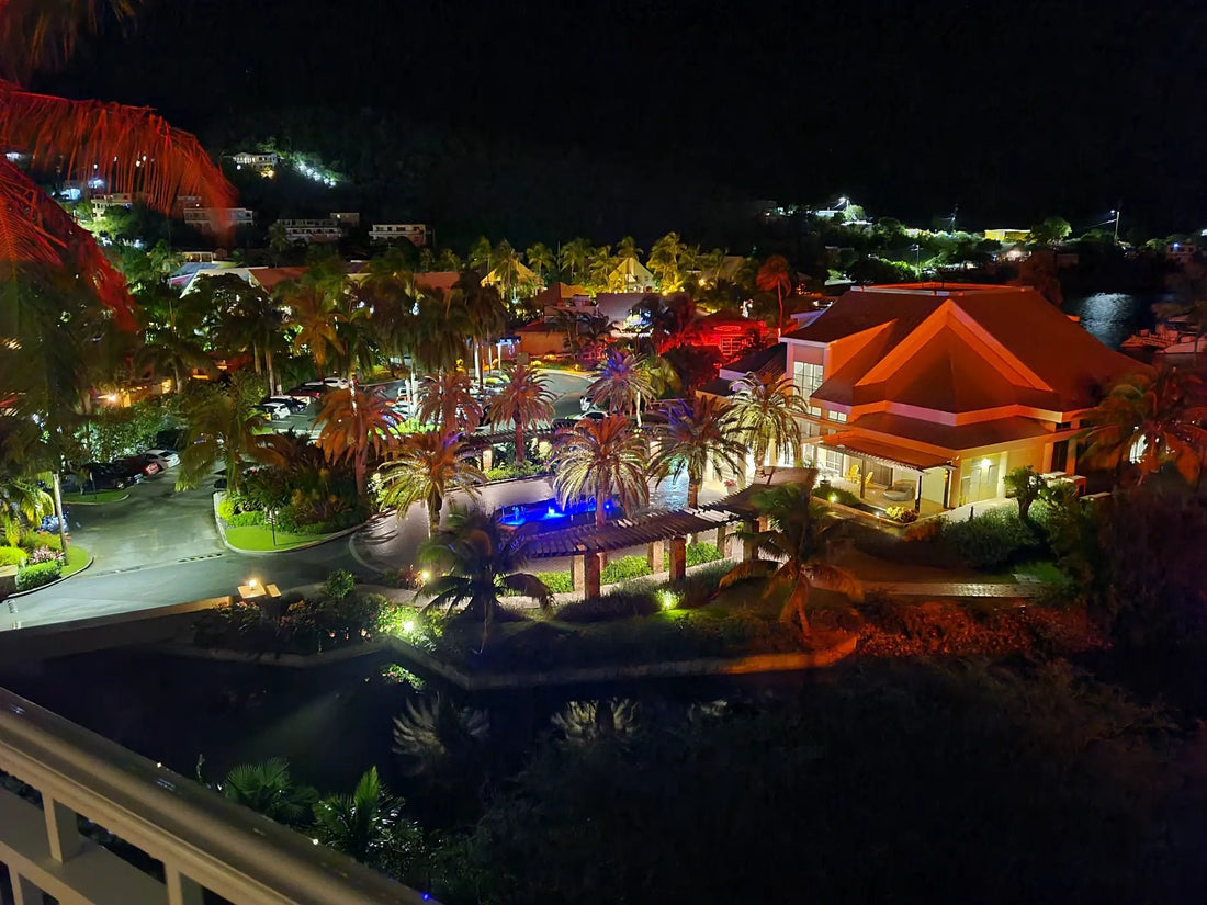 Margaritaville St. Thomas resort at night — pool and palm trees lit up